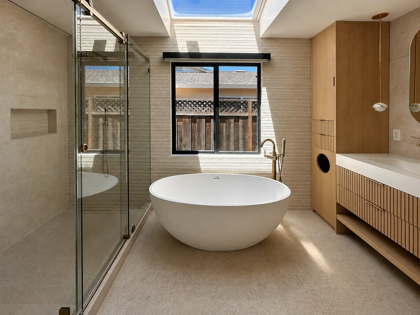 Click to view full screen Primary bathroom with freestanding tub beneath a skylight