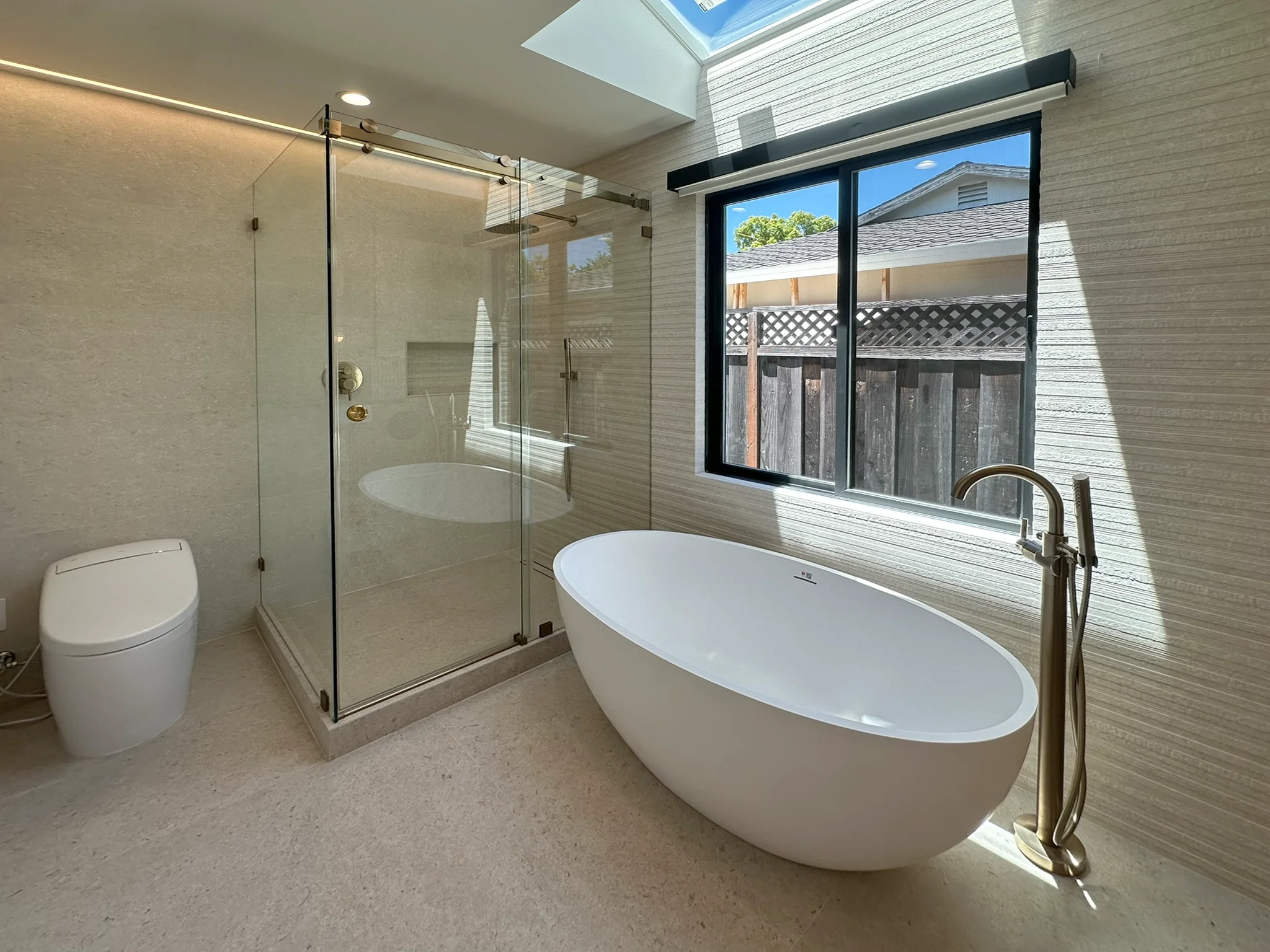 Click to view full screen Primary bathroom shower and tub seen from the vanity wall