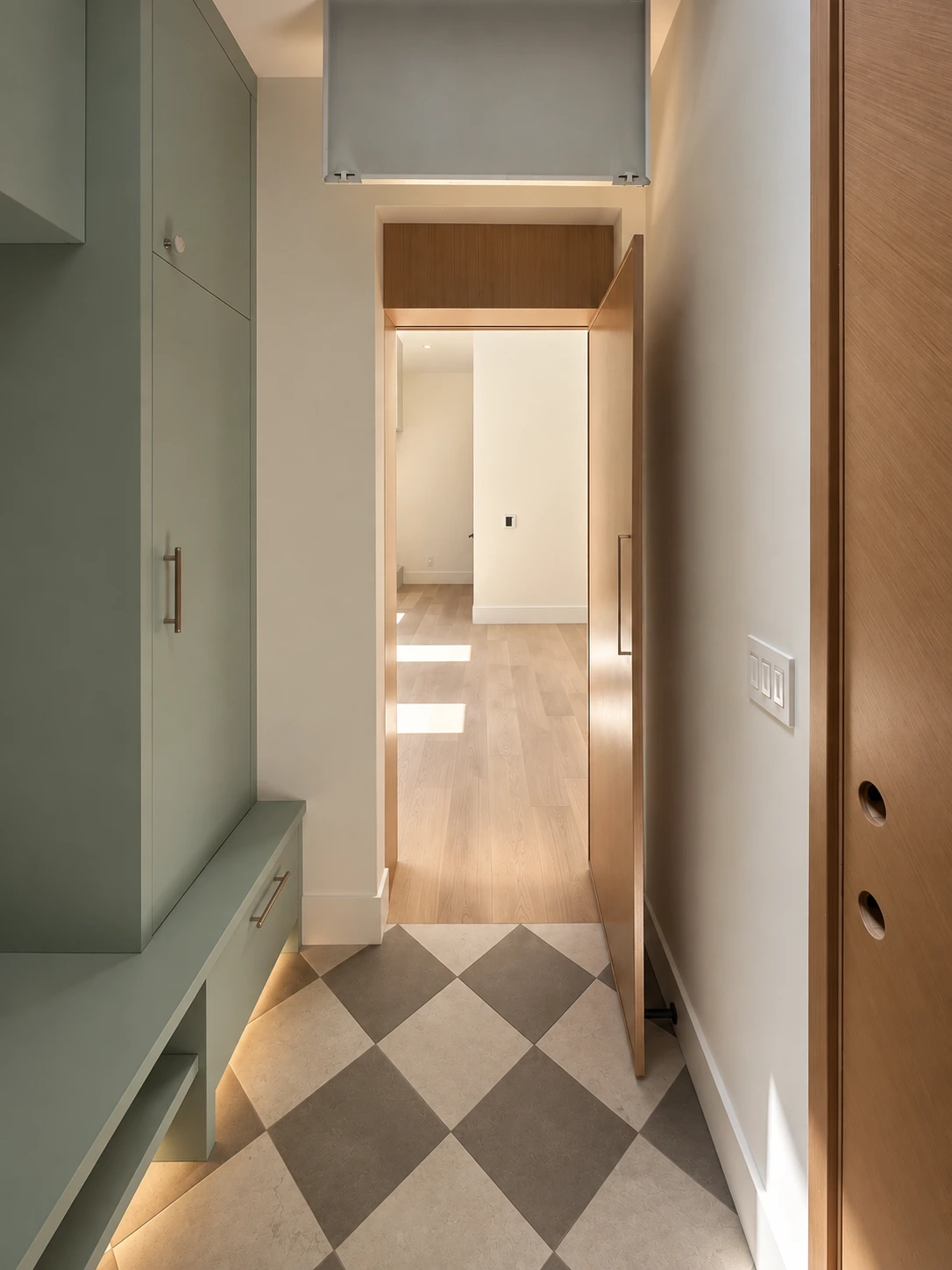 Click to view full screen Mudroom passage with bench seating and checkerboard stone floor